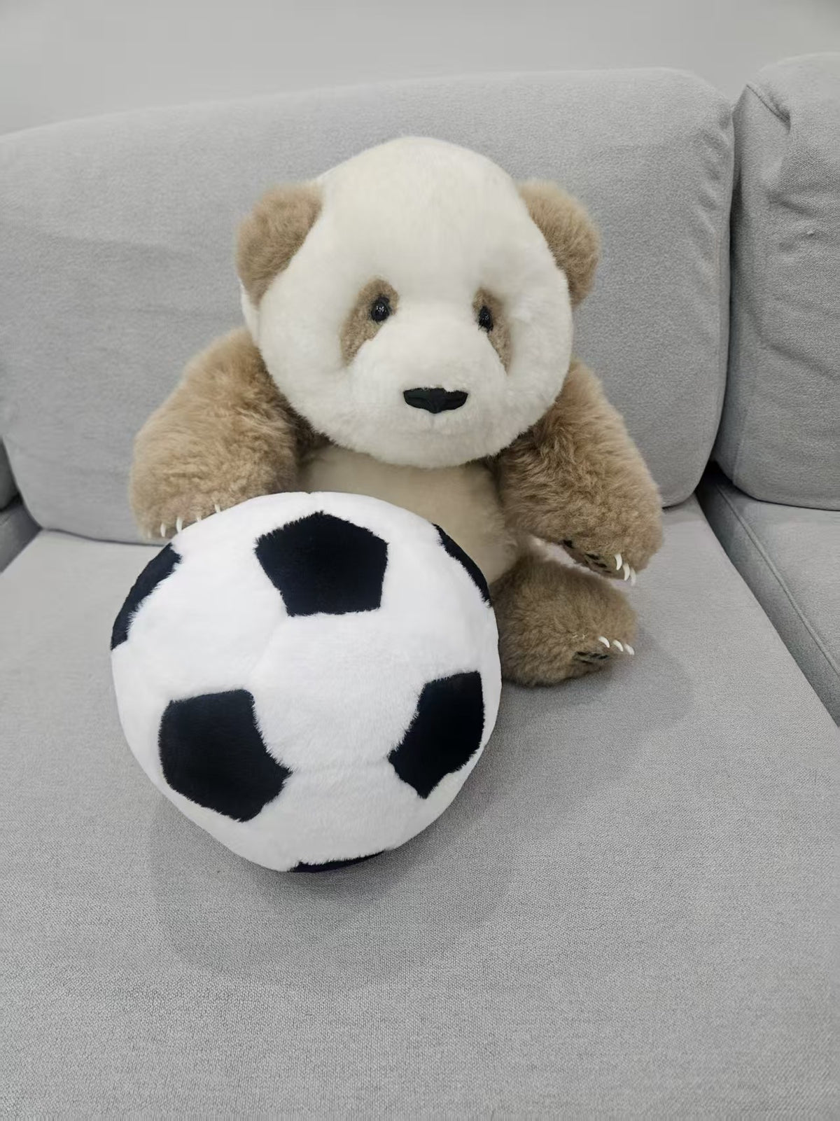 Brown panda and football plush set detail close up